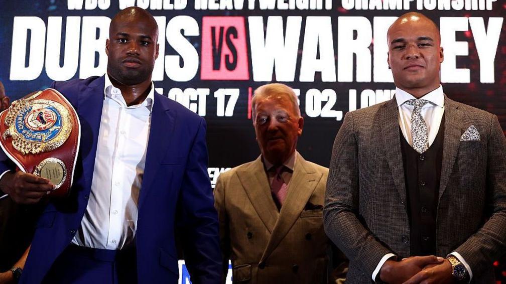 Daniel Dubois holds the WBO heavyweight title on his shoulder and stands next to Fabio Wardley