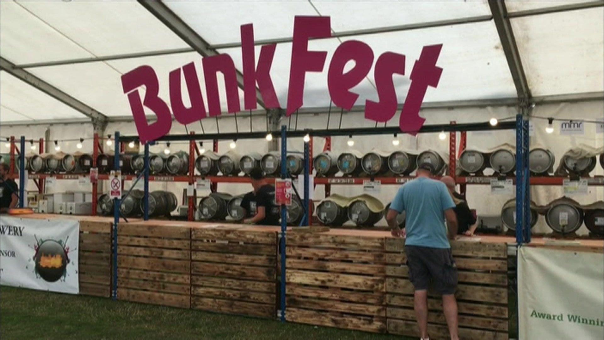 A large pink BunkFest sign above a bar under a marquee.