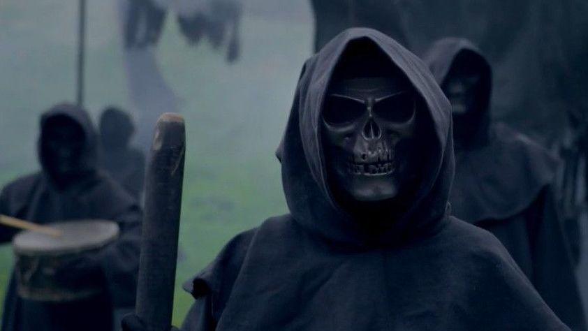 Death marchers in skull masks and black robes