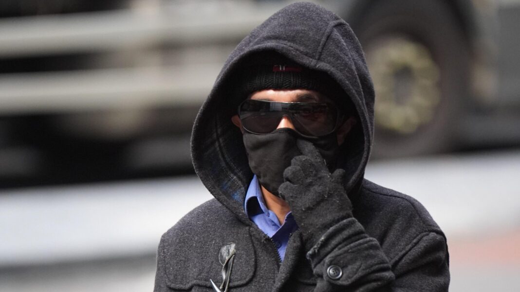 Civil servant faked illness with make-up to juggle five jobs, court hears A 55-year-old man wears sunglasses, a hat, hood and gloves as he arrives at court.