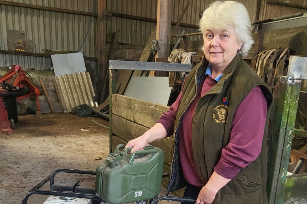 Bridgette Clamp with her electricity generator wearing a green body warmer and maroon jumoer