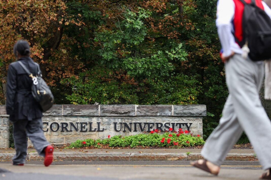 ‘Dark cloud’ hangs over Cornell campus as anger at frat rape investigation grows People walk past a sign with the words 'Cornell University' with a flowerbed of red and green flowers in front of it and browning autumnal leaves in the background, taken in Ithaca on Thursday.