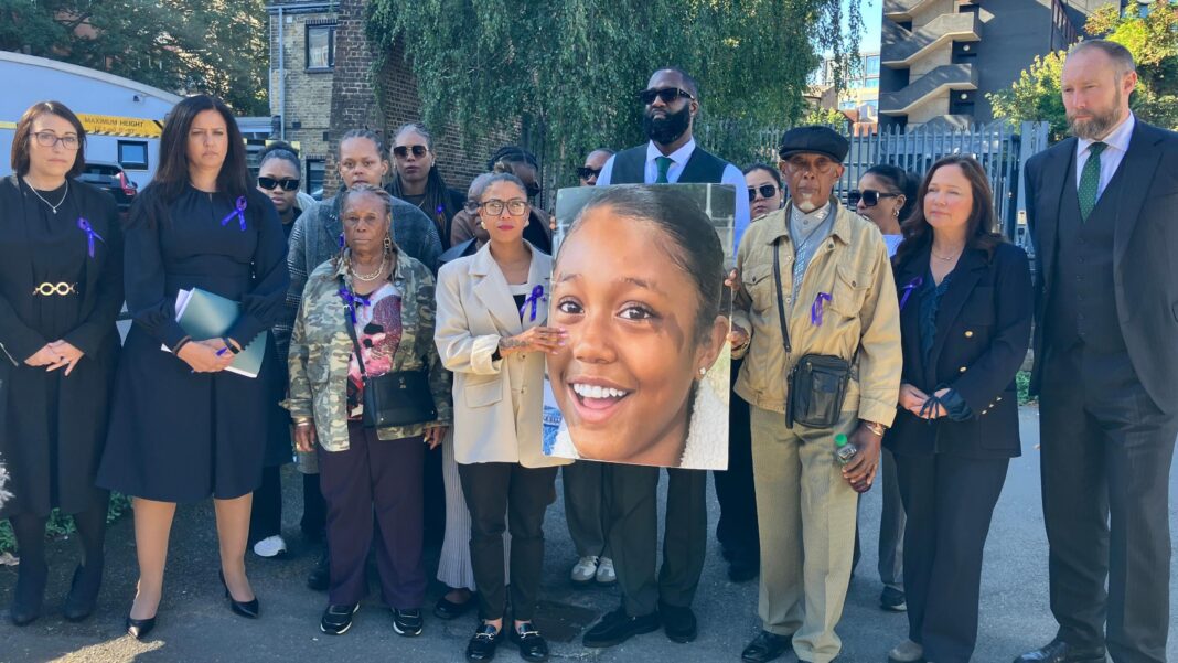 Death of 12-year-old girl prompts call for allergy management ratings A group of people wearing purple ribbons hold a large image of Mia.