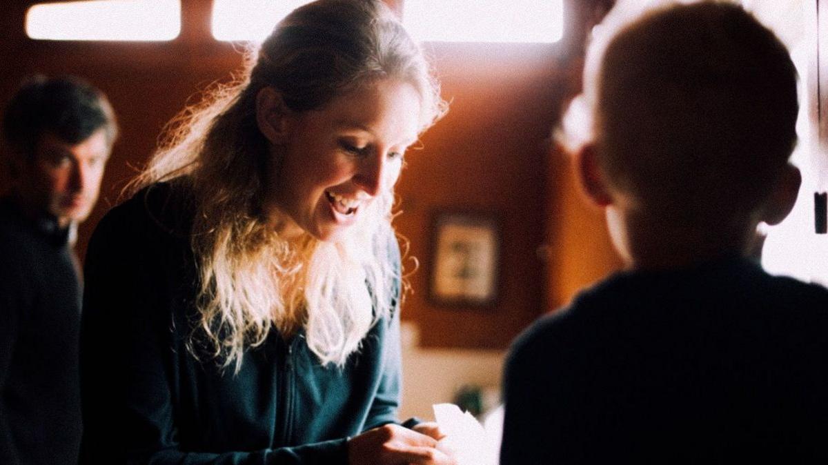 A close-up of Elizabeth Holmes smiling in the new behind-the-scenes film