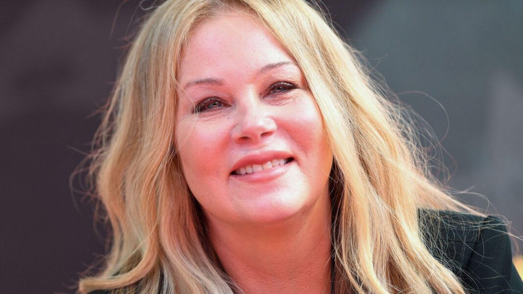 Christina Applegate pictured wearing a black top and smiling towards the camera