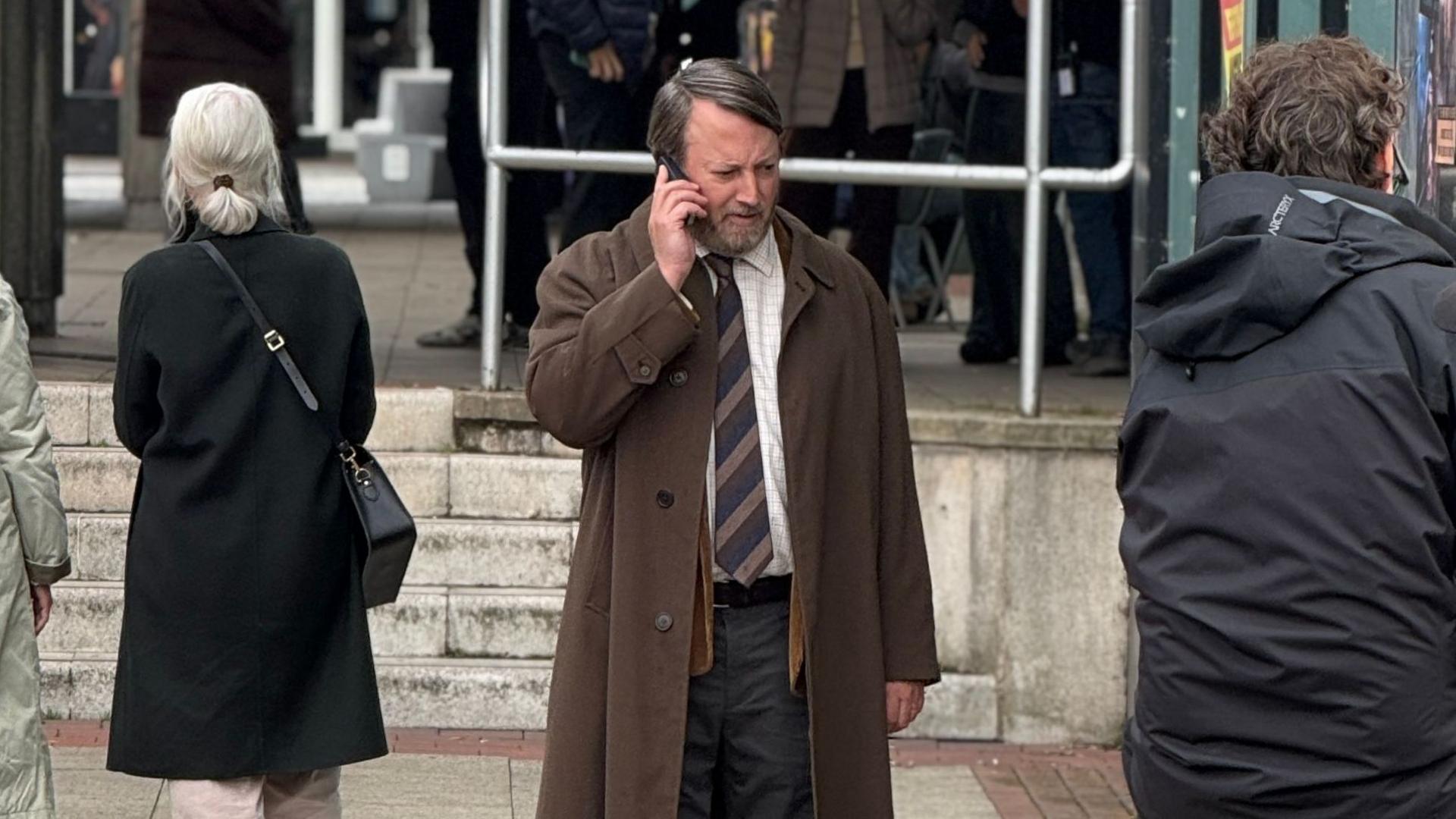 David Mitchell filming Ludwig in costume, acting as if he is taking a phone call