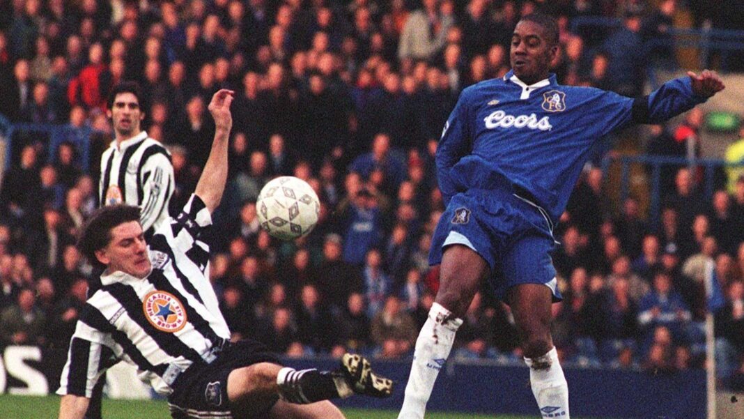 Eddie Newton kicks the ball over a sliding Newcastle United footballer during a match for Chelsea.