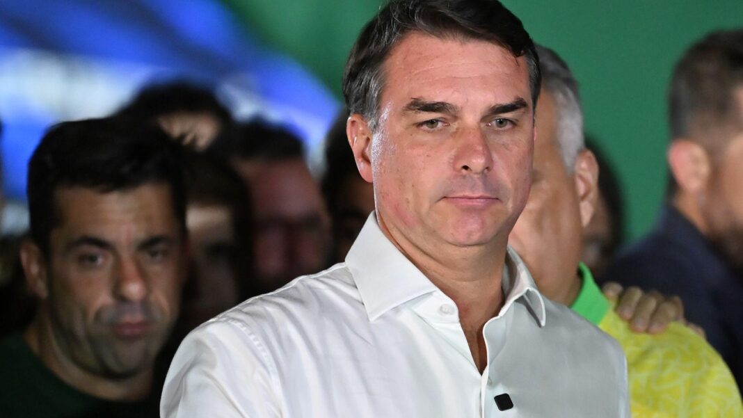 Confusion about Flávio Bolsonaro’s whereabouts as Argentina says he flew to Ecuador Brazilian presidential candidate Flavio Bolsonaro of the Liberal Party speaks after losing the presidential runoff election, in Brasilia on 25 October, 2026. He is wearing a white shirt with an open collar. He is gesturing with one hand. Behind him, his supporters look on.