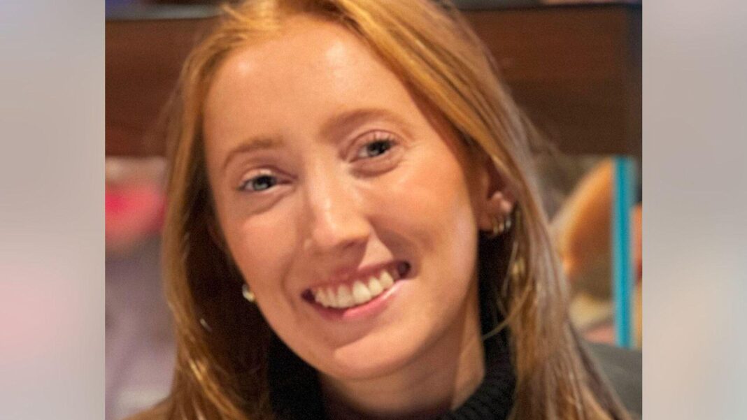 Close up of Chloe Moffat, who has long, red hair, smiling at the camera.