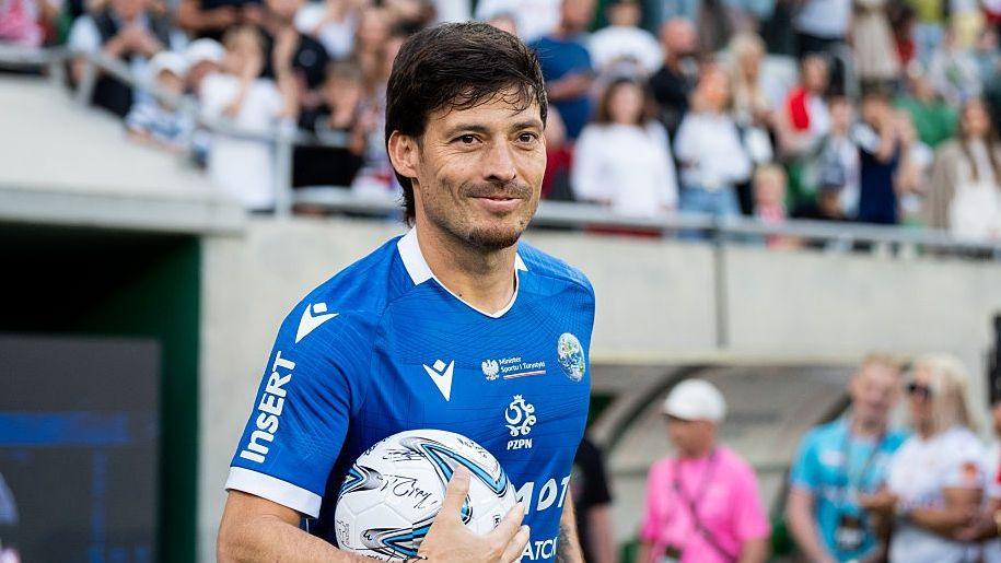 David Silva smiles while holding a football