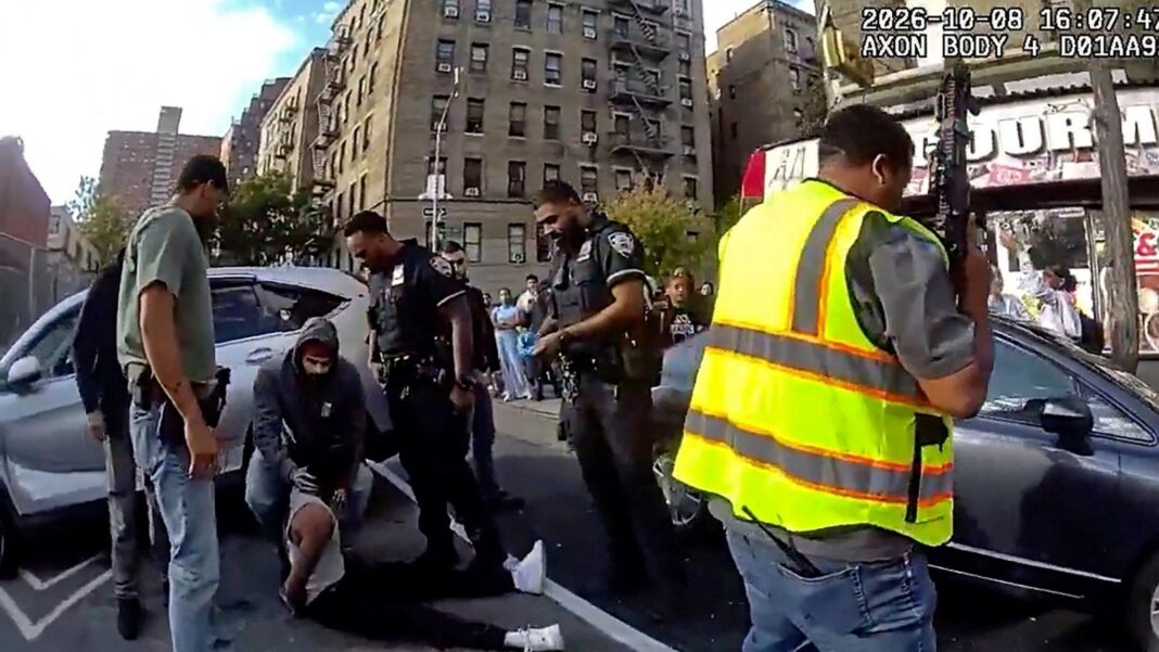 US immigration officials defend ICE agents who shot man in same car as child Footage from a New York police officer's body camera shows a man sat on the ground by a silver car with four other men, including police officers, stood around him. One man, wearing a hooded jumper, bends over him and touches his neck. A man holding a large gun and wearing a high-visibility vest is seen in the foreground on the right of the shot, in front of a dark car