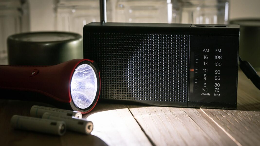 Sharp rise in sales of some essential goods after government call to stock up A red torch shines a beam of light on a black portable radio.