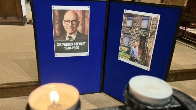 Candles lit against a backdrop showing a poster of Sir Patrick Stewart.