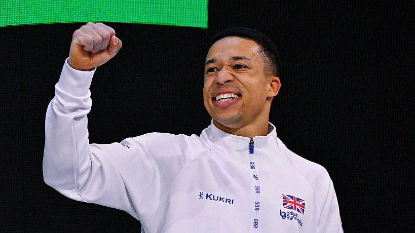 Bronze medallist Great Britain's Joe Fraser celebrates on the podium after the Men's Individual All-Around Final