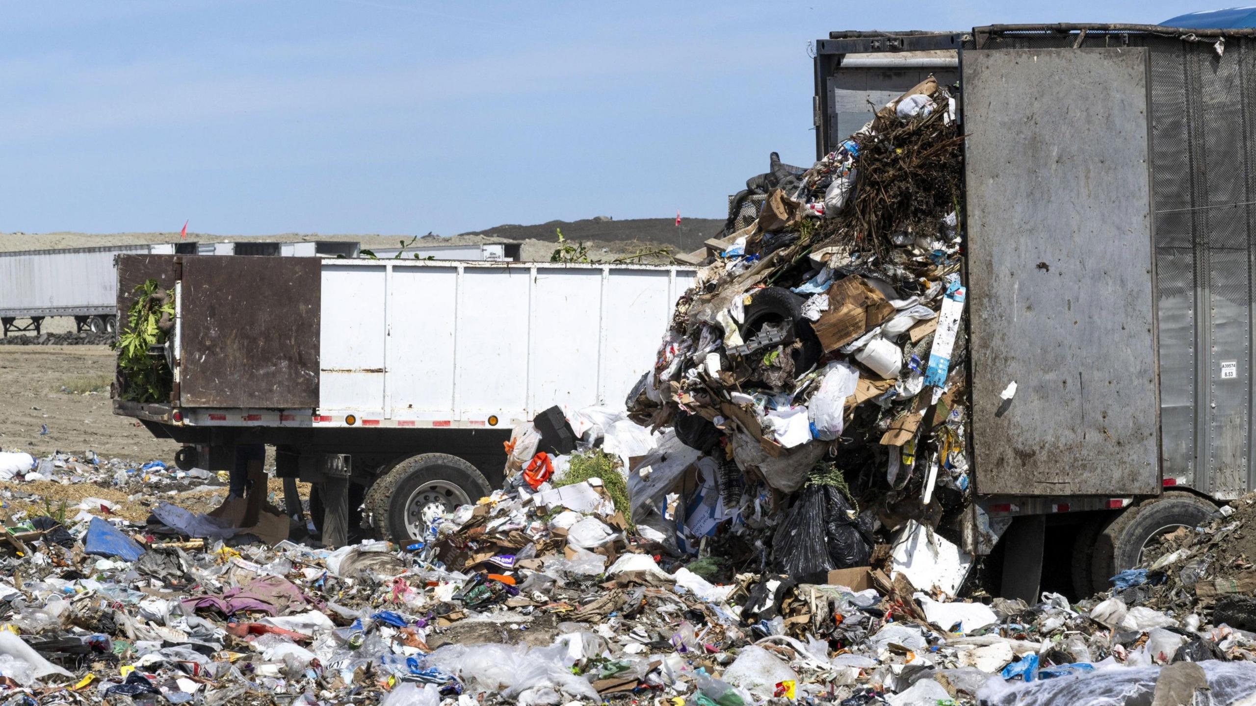 Trucks dump rubbish at a landfill in California.