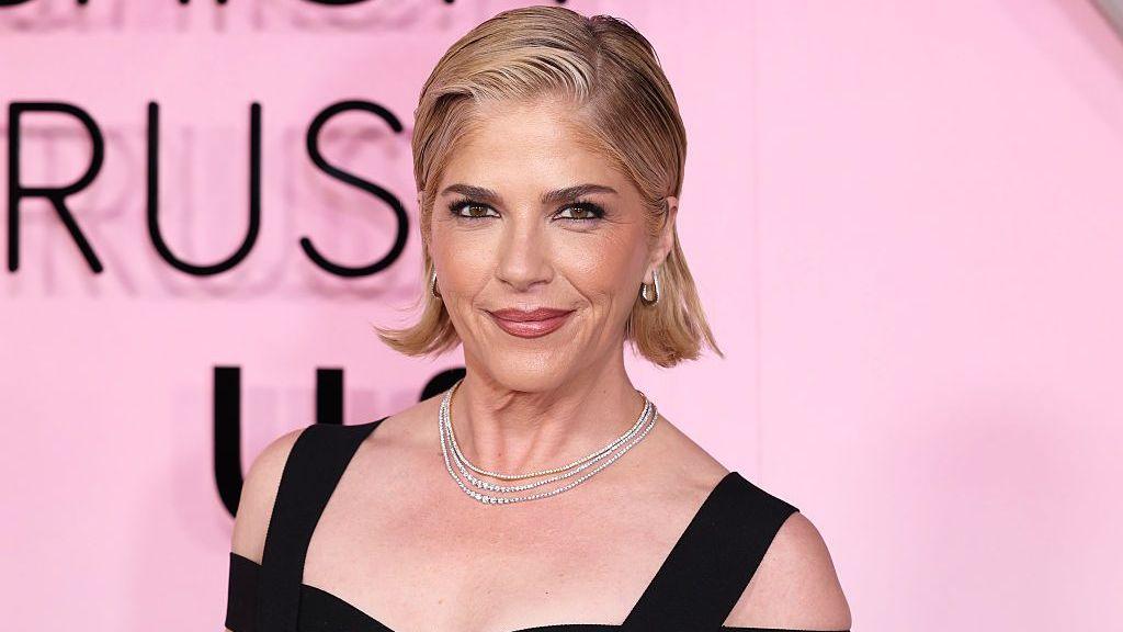 US actress Selma Blair smiles during event arrivals while wearing diamond necklaces and black strapped gown.