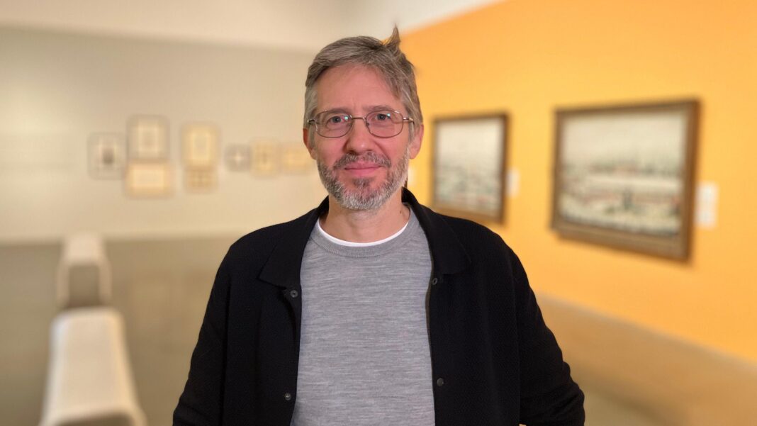 ‘Why we think Milton Keynes can be a City of Culture’ Milton Keynes Gallery director Anthony Spira photographed in a gallery exhibition space with paintings on the wall behind them.
