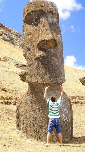 A man stands wearing the Wright top in front of one of the famous stone heads at Easter Island.