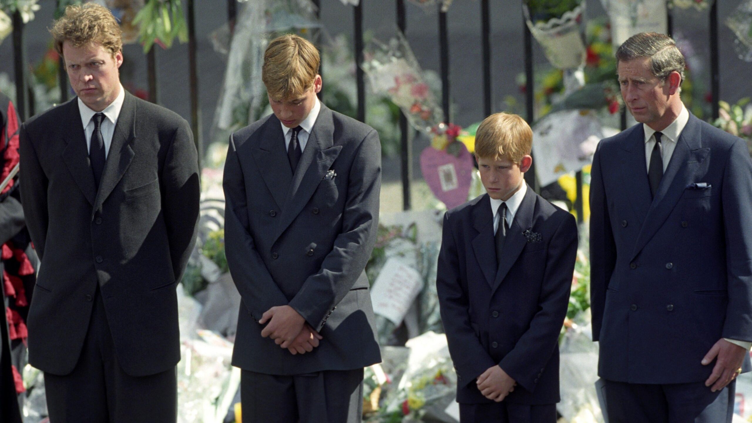 File photo dated 06/09/97 of Prince Charles (now King Charles III), Earl Spencer, Prince Harry and Prince William walk slowly behind the funeral cortege of Diana, the Princess of Wales at her funeral at Westminster Abbey. All four bow their heads and wear dark suits, with bouquets of flowers visible on railings behind.