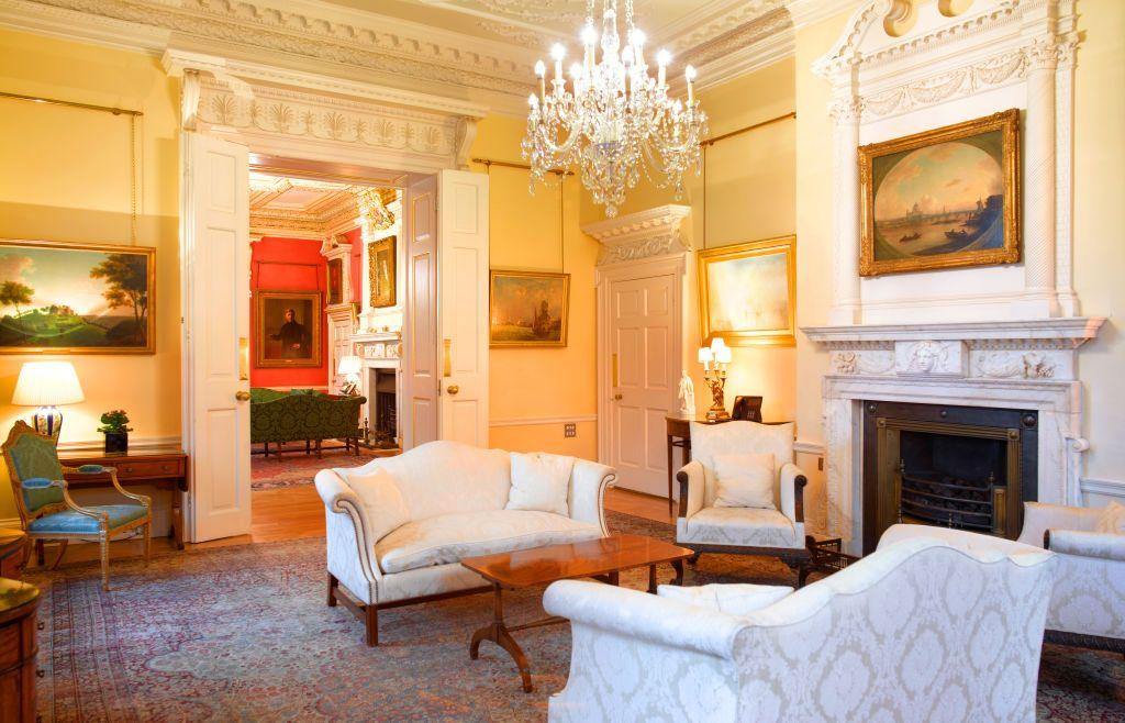 Downing Street's grand white room is pictured with elaborate furniture, a fire place and a chandelier.