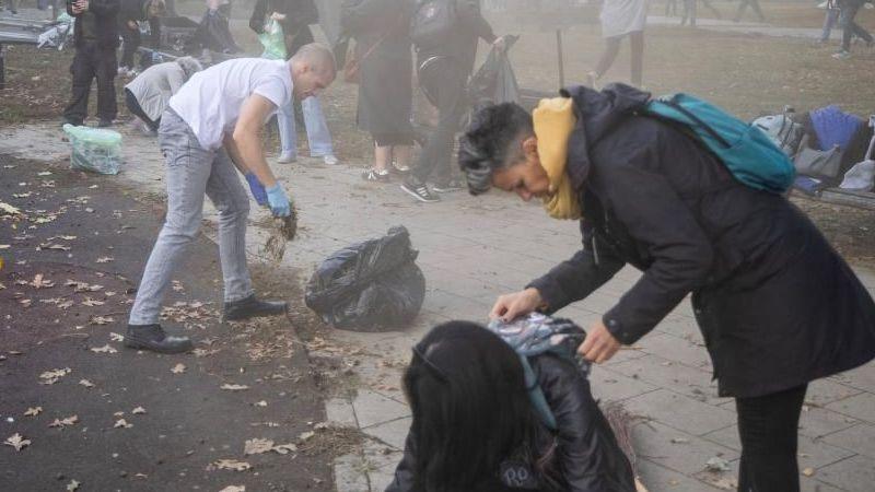 People clean Pionirski Park, the site of a former government-backed counter-encampment, in Belgrade, Serbia, October 26, 2026.