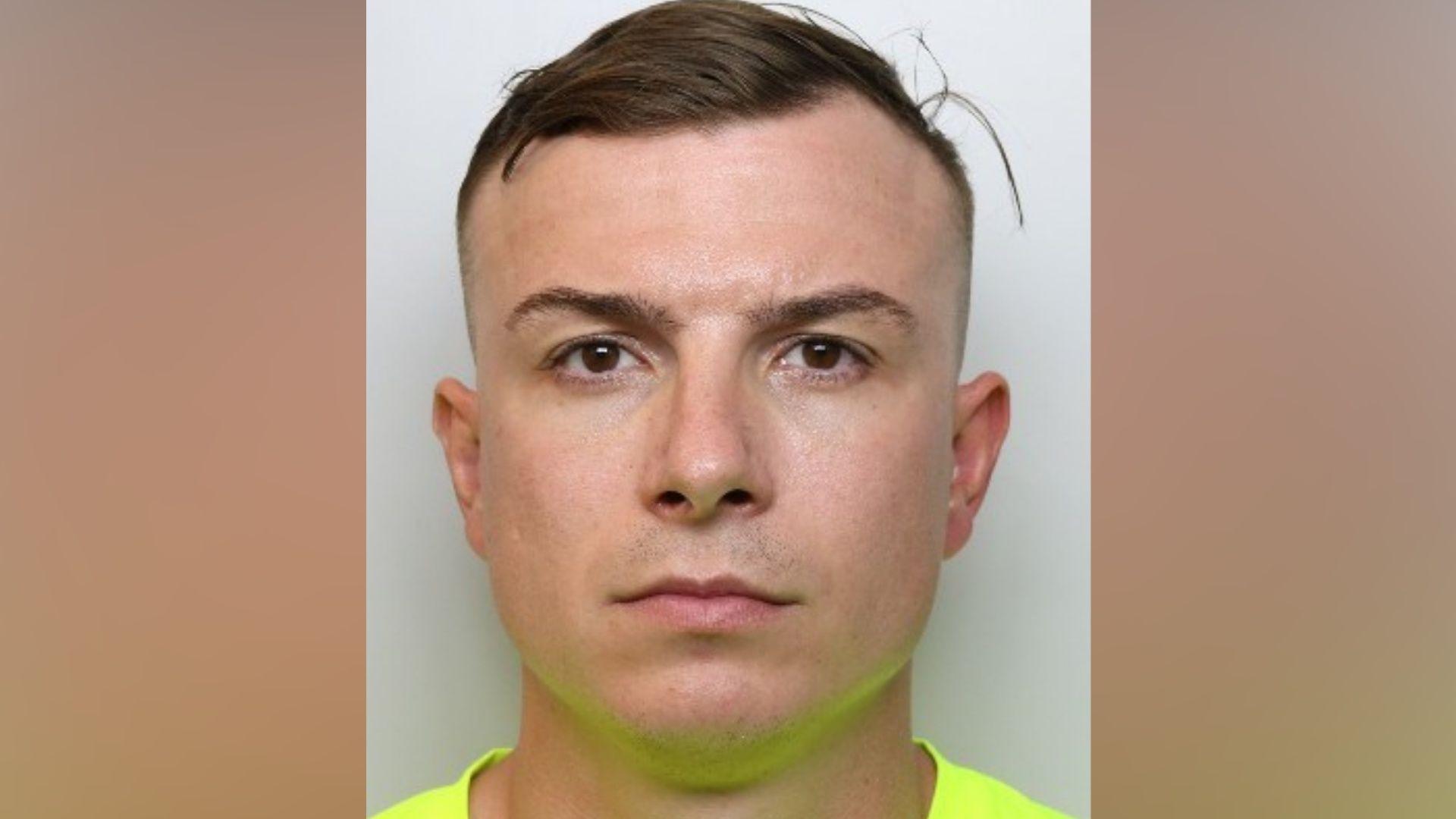 A custody picture of a man looking straight at the camera wearing a bright yellow top.