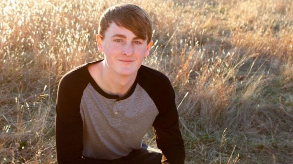 Ethan Weems kneeling down in a field