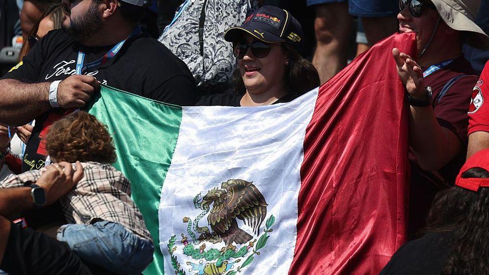 A fan holds up a Mexico flag at the Mexico City Grand Prix