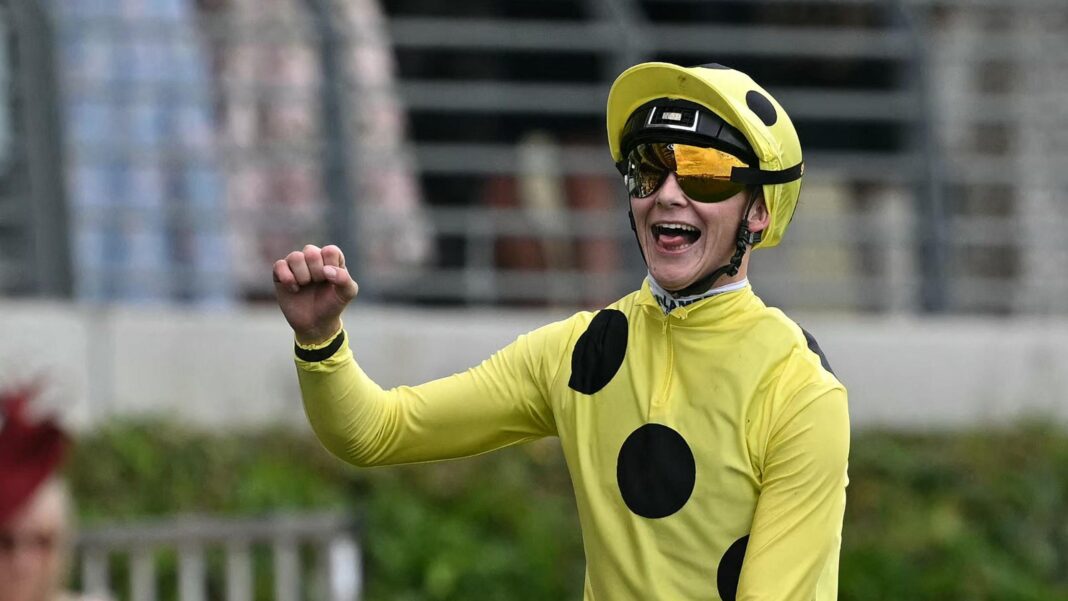 Billy Loughnane wearing a riding helmet, sunglasses and a yellow top with three black spots running diagonally across his chest