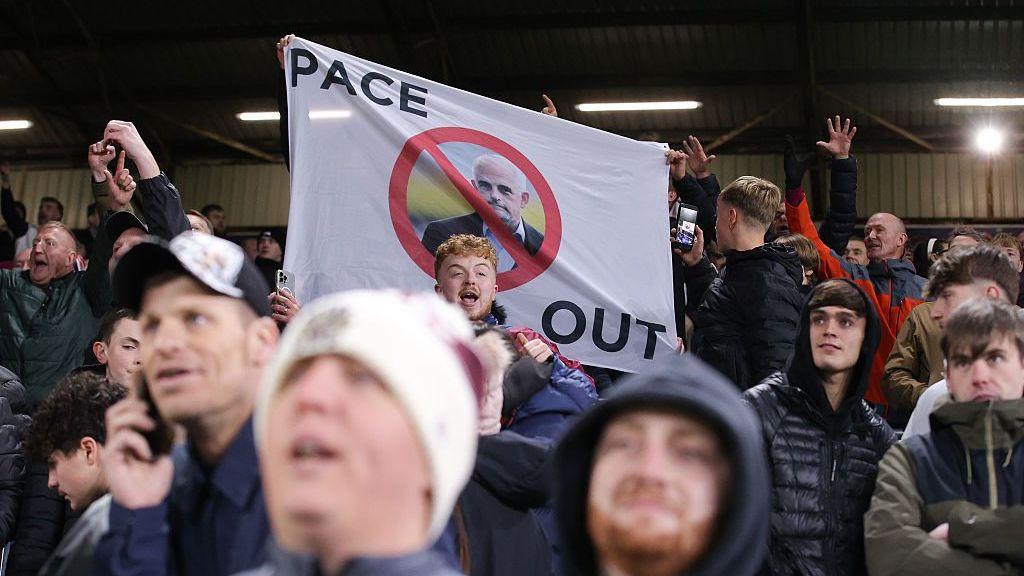 Burnley supporters protest against their owners with a flag during the Championship against Wolverhampton Wanderers