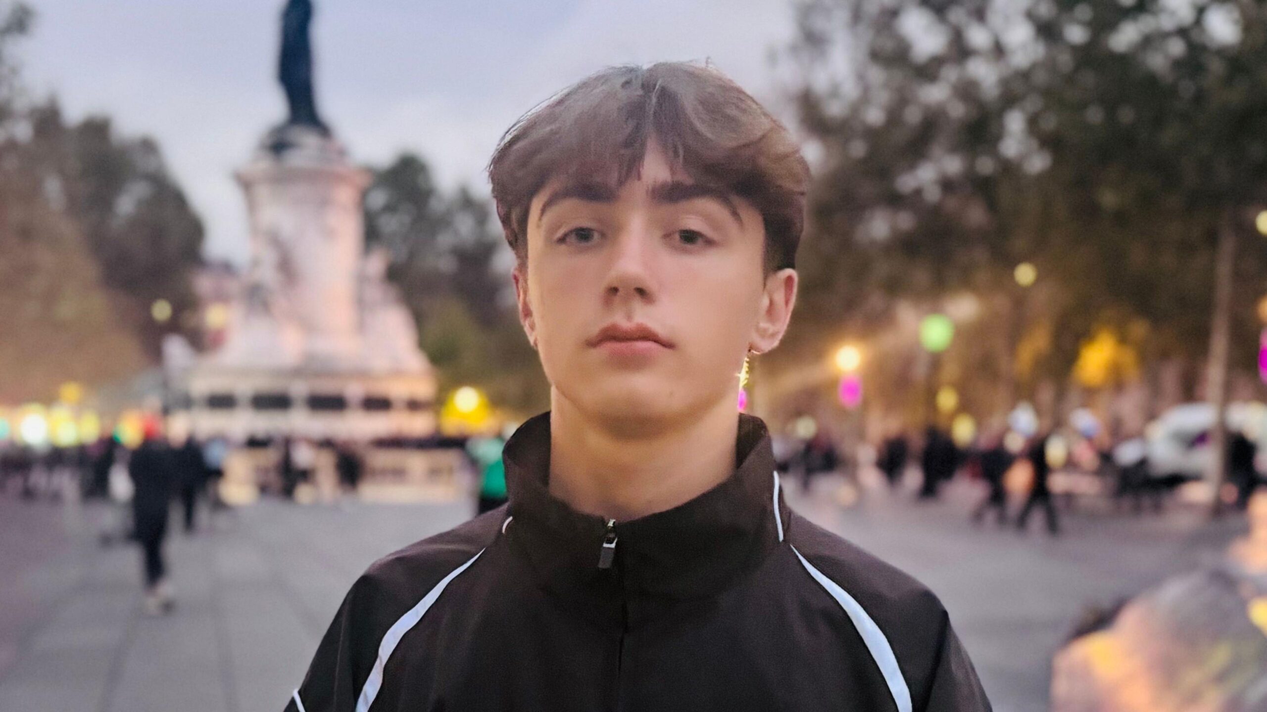 Kaspar, who wears a black zip-up tracksuit top, poses for a photo in Paris.