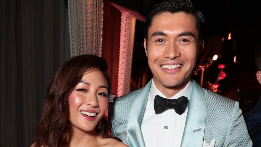 Headshot of Constance Wu and Henry Golding smiling a a black tie event