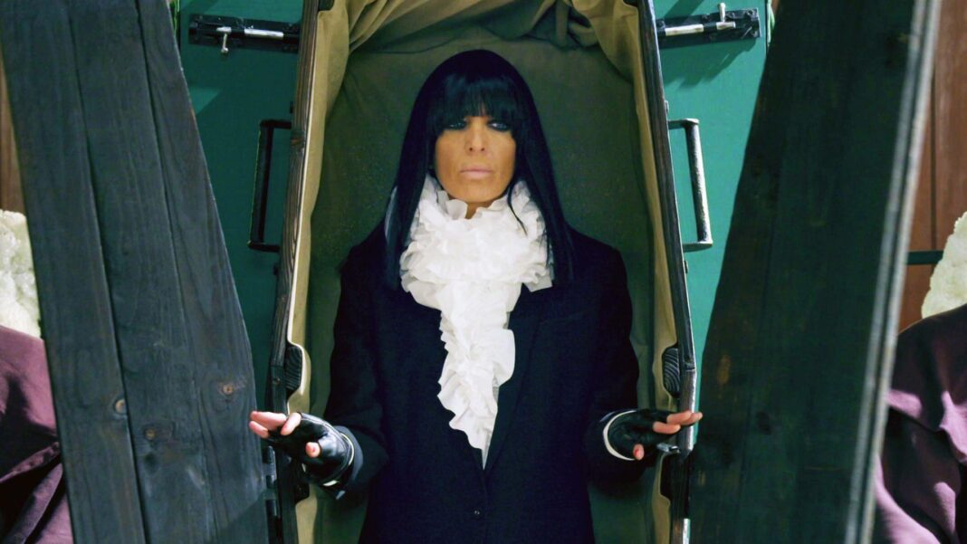 Claudia Winkleman emerging from a coffin