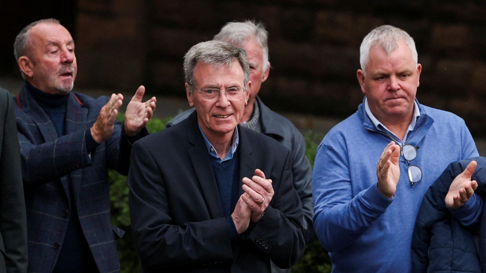 Garvaghy Road Residents’ Coalition spokesman Breandán Mac Cionnaith and three oter men supporting him appuald as they walkto the High Court in Belfast.