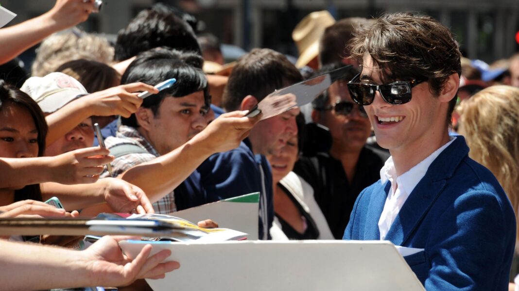 How Breaking Bad’s RJ Mitte changed the way we see cerebral palsy RJ Mitte in dark glasses and a blue suit, smiling and signing autographs next to a crowd of fans holding out their arms, in 2013