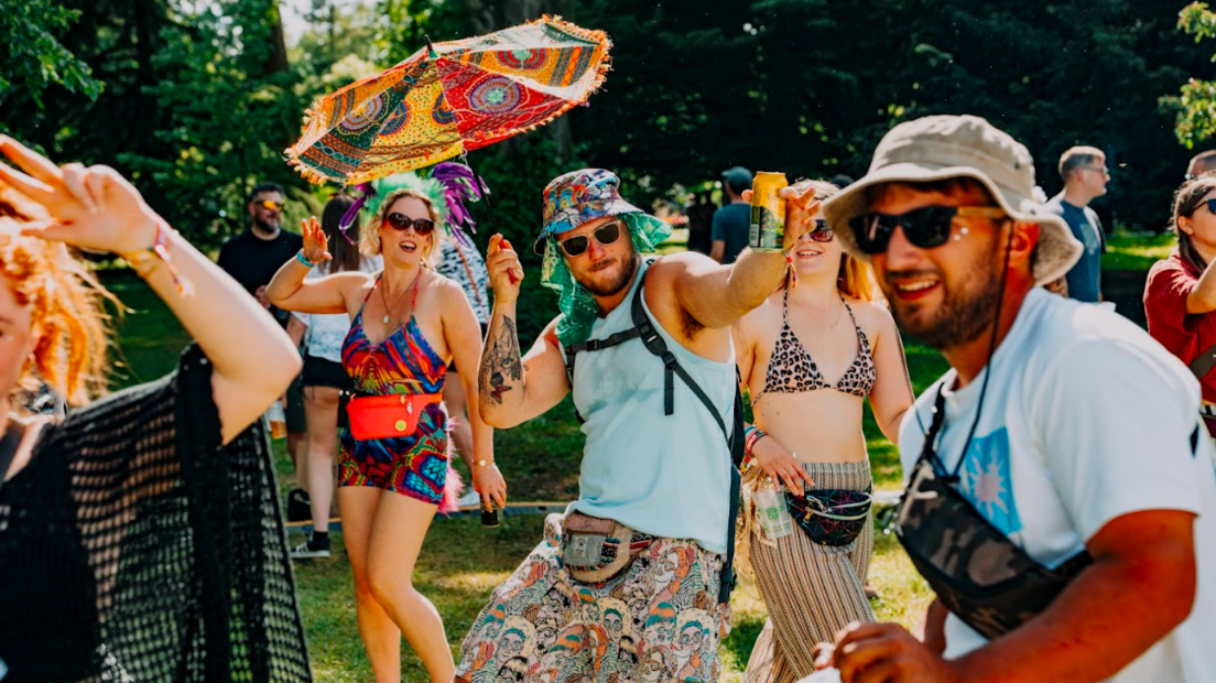 People dancing in colourful outfits, shorts and dresses