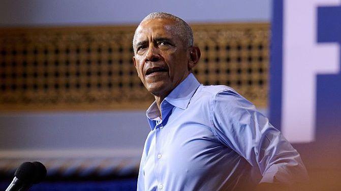 Obama wears a blue shirt while speaking into a microphone during a campaign rally in Ohio