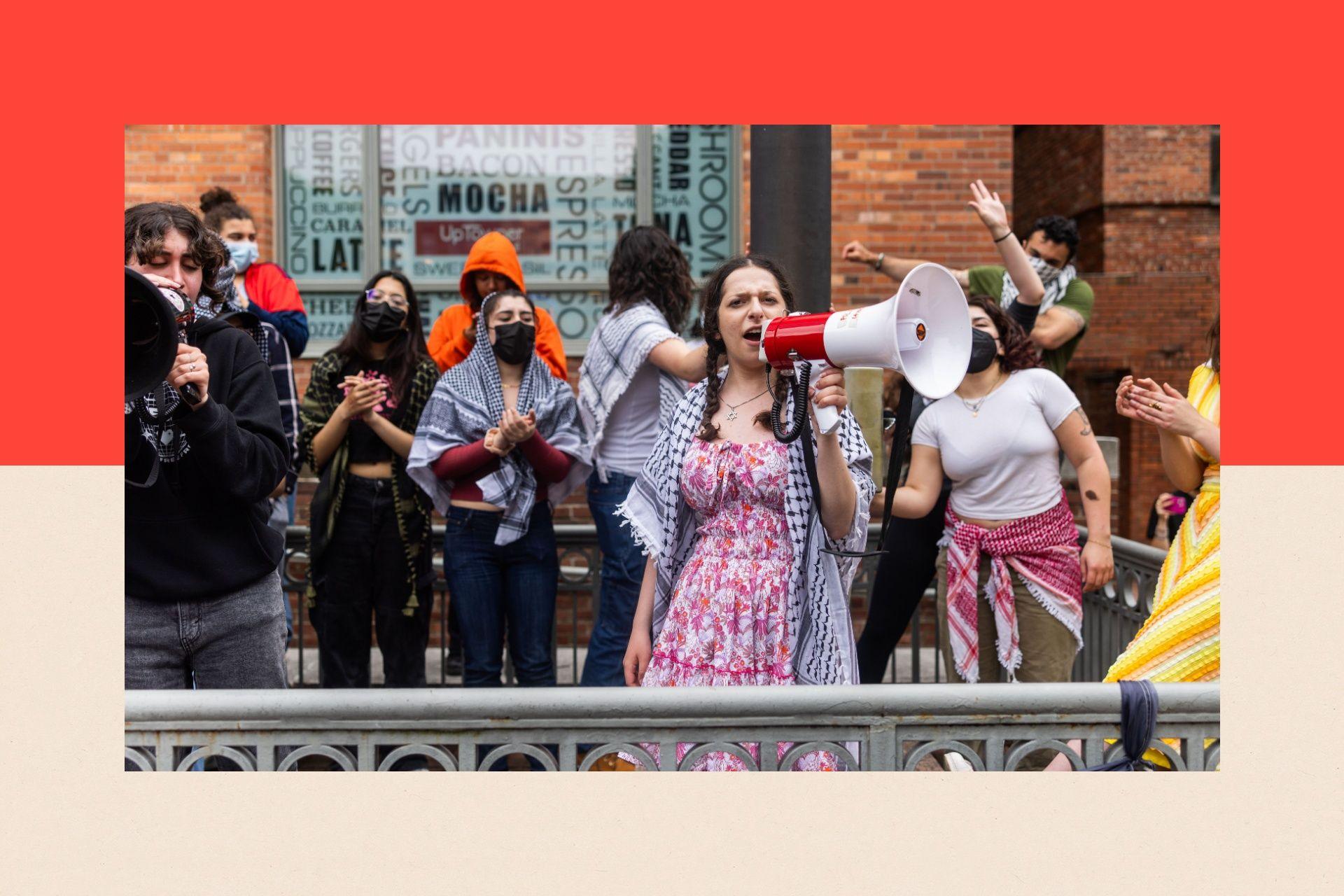 A group of student protesters wearing keffiyehs. One of them holds a megaphone