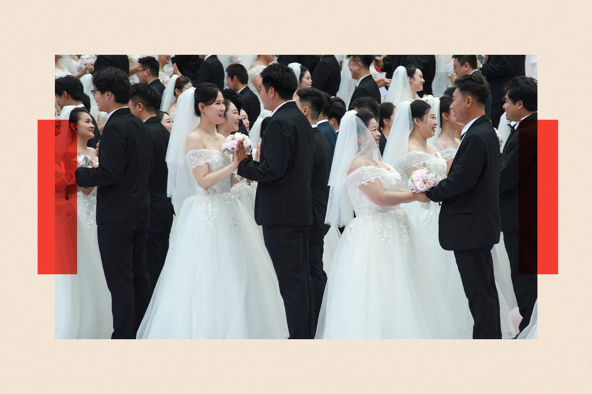 A communal wedding of brides wearing puffy white dresses and grooms wearing black suits