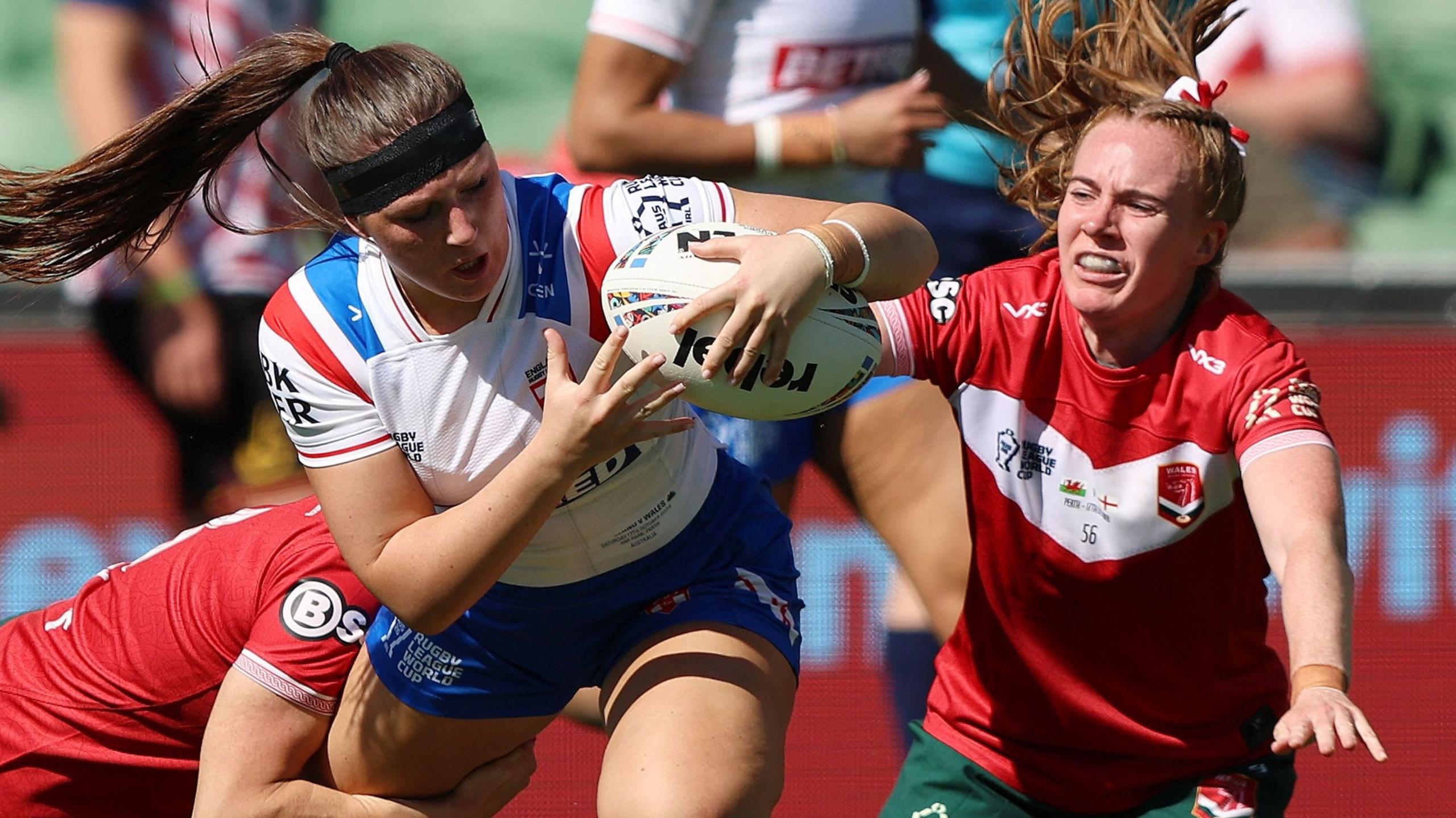 Connie Boyd holds on to the ball as two Wales players look to halt her progress