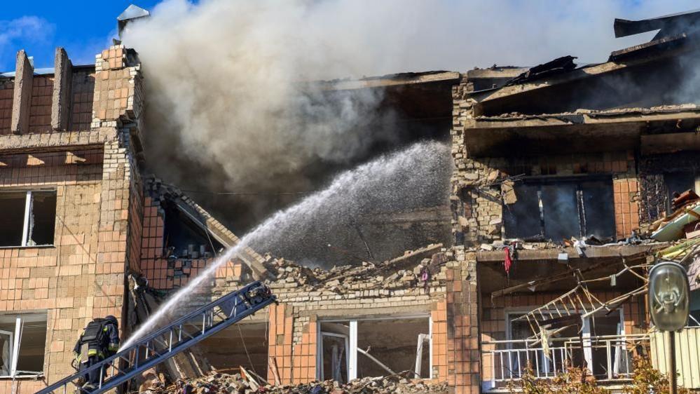 Ukrainian rescuers work at the site of a Russian drone strike on a residential building in Kharkiv, north-eastern Ukraine on Monday