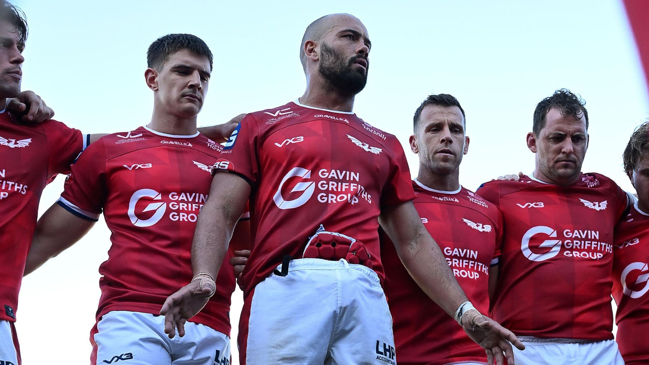 Josh Macleod in red jersey and white shorts addresses the Scarlets players after defeat by Dragons