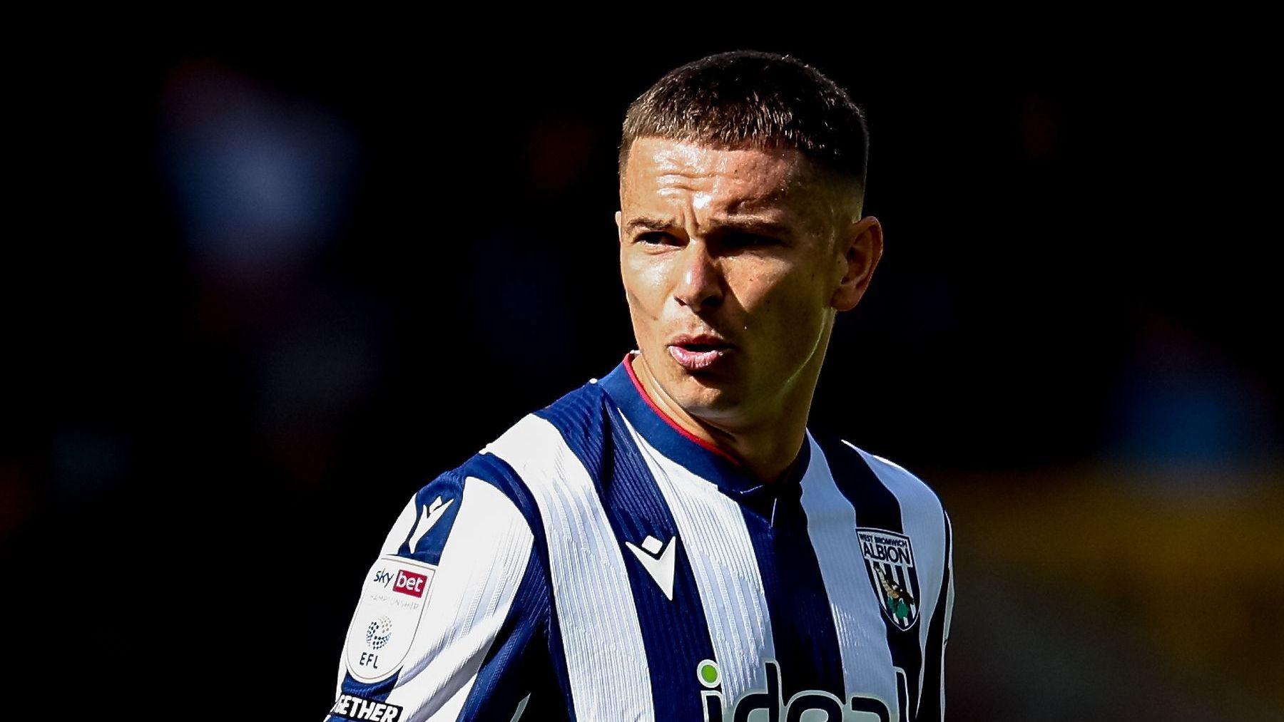 A close-up of Conor Townsend wearing a West Bromwich Albion home shirt
