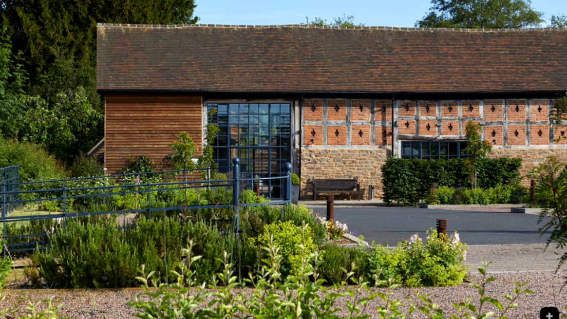 Native is described as a countryside retreat located on the Herefordshire-Worcestershire border. It has a barn conversion building with large windows and gardens around it. ​