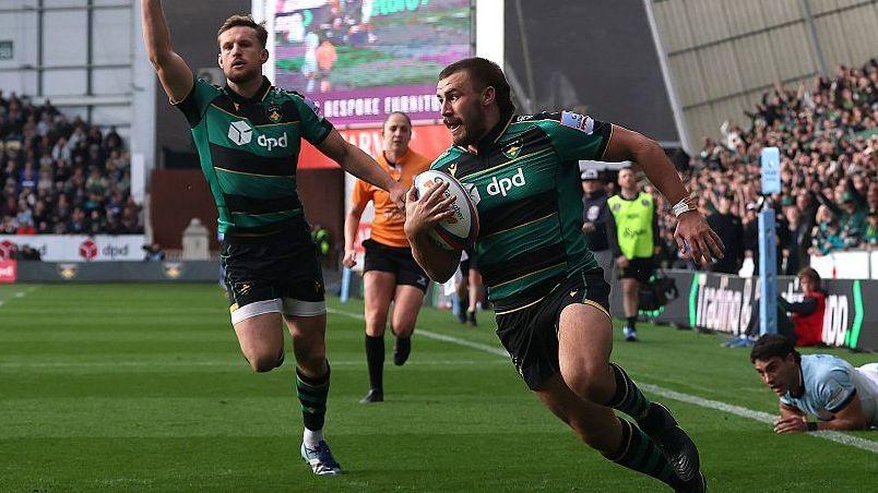 Ollie Sleightholme runs over the try line with the ball tucked under his right arm to his body as a team-mate runs in celebration behind