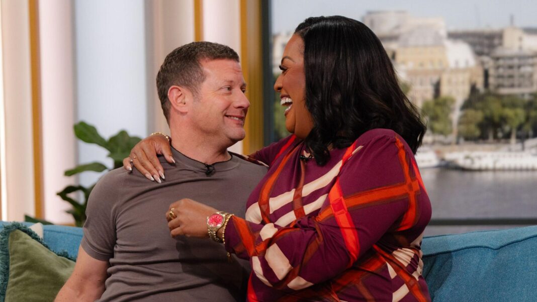 Alison Hammond laughing with an arm around Dermot O'Leary, who is smiling nervously, on the set of This Morning