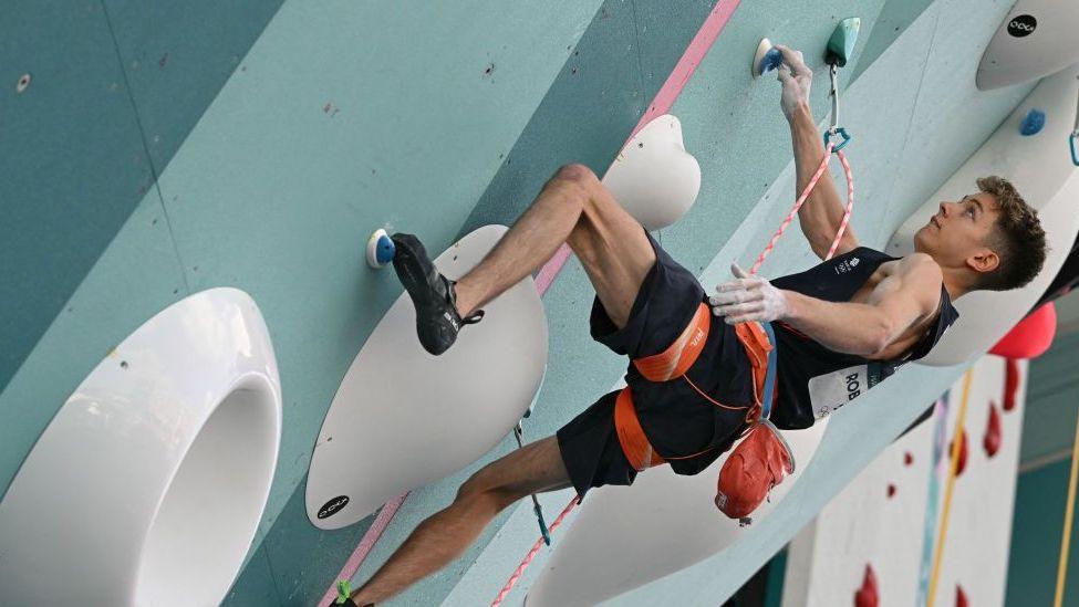 Great Britain's Toby Roberts competing on a climbing wall