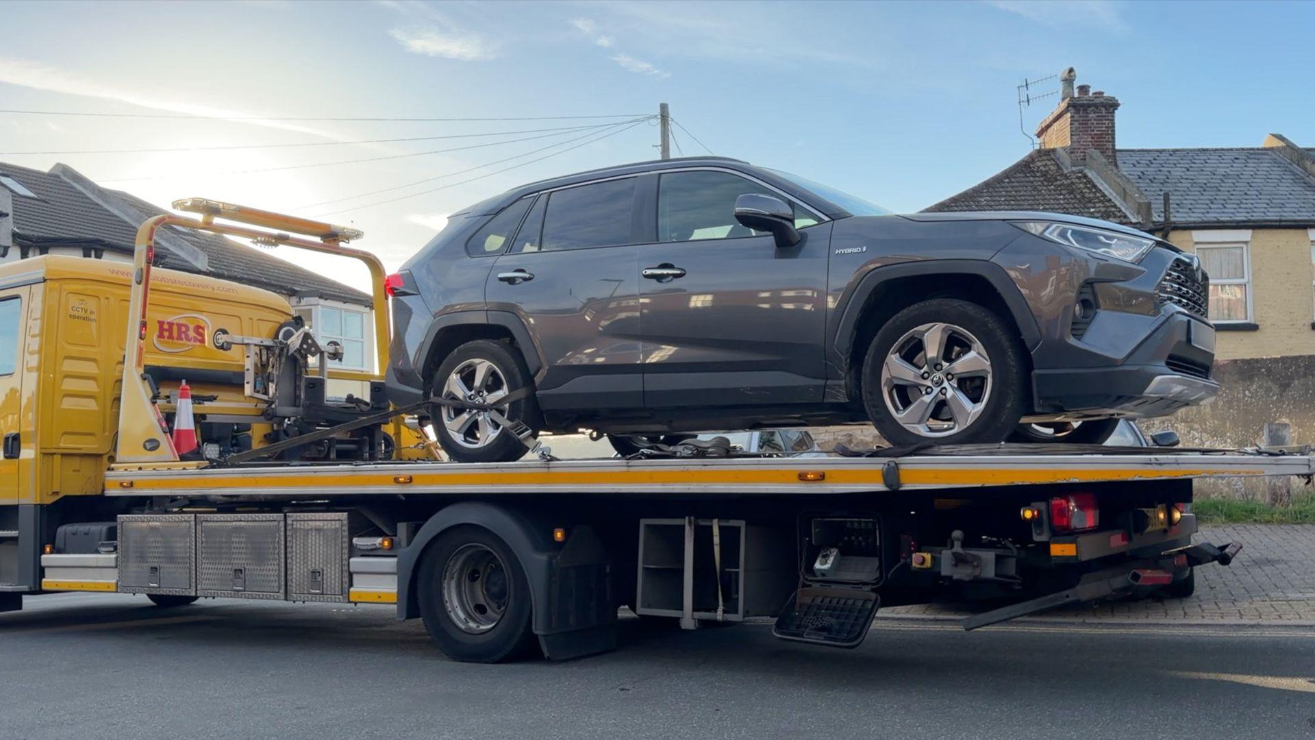 A Toyota SUV loaded onto a recovery truck after being tracked down by police