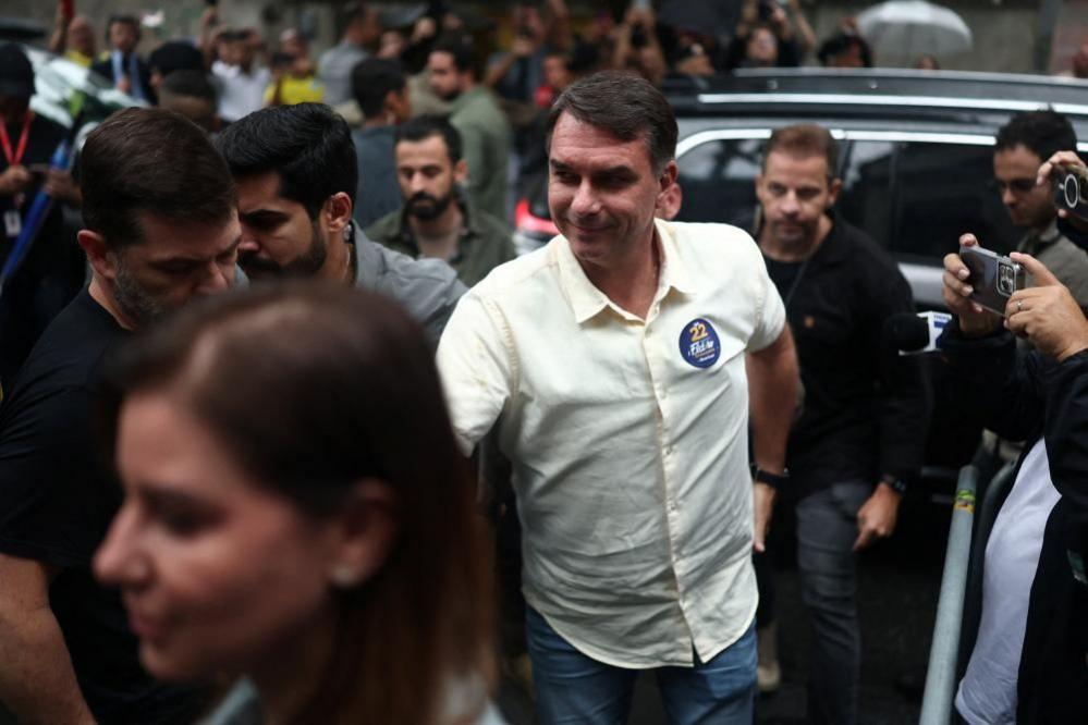 Flavio Bolsonaro, wearing a light shirt, arrives to cast his vote at a polling station in Rio de Janeiro, Brazil.