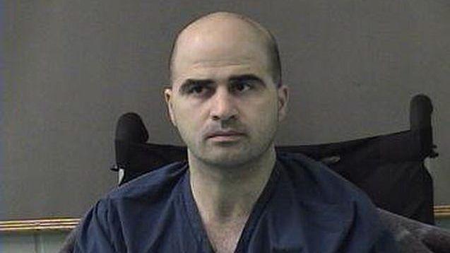 Nidal Hasan in jail jumpsuit, seated on wheelchair